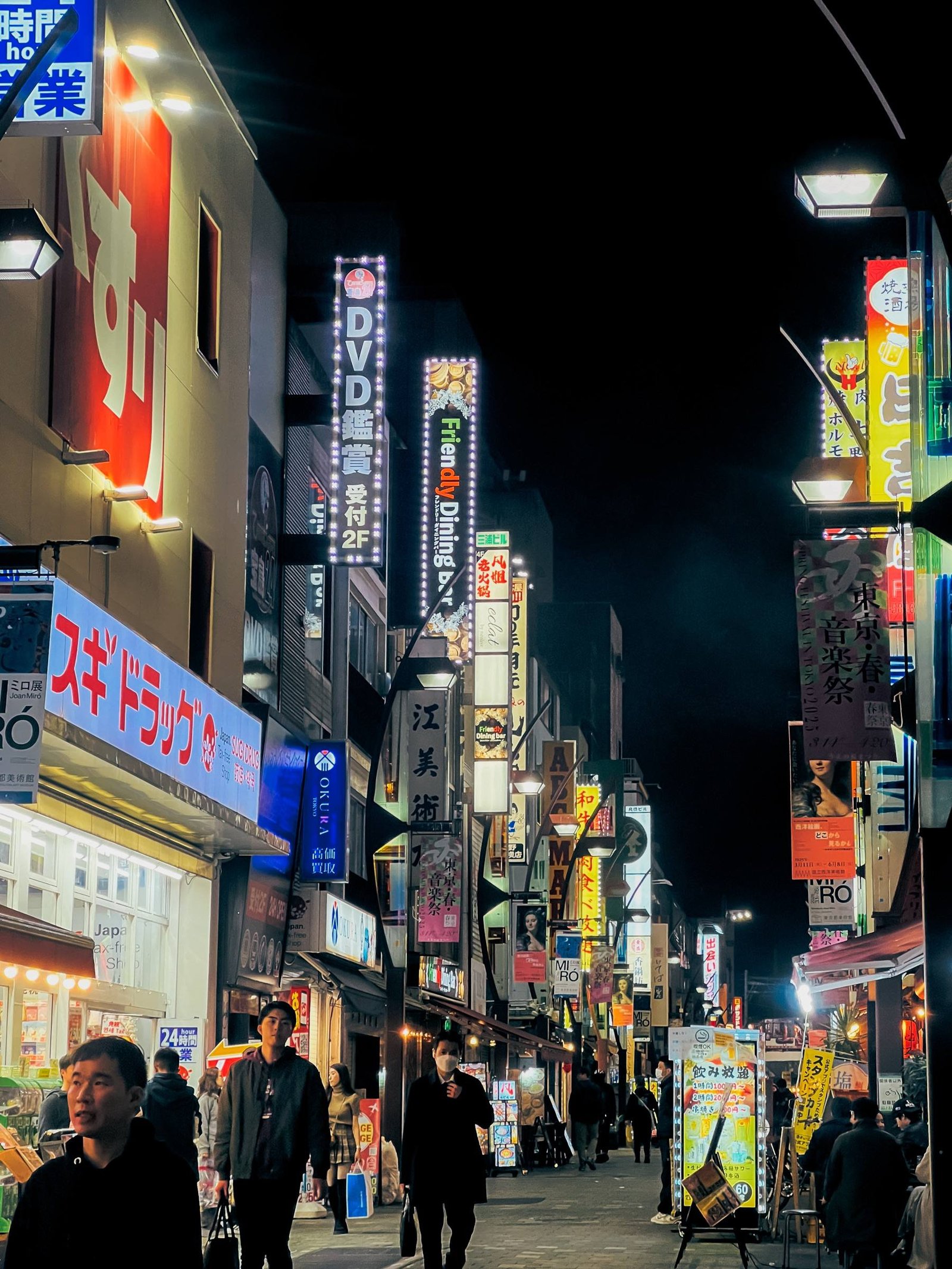 Una strada di Tokyo di notte piena di insegne al neon