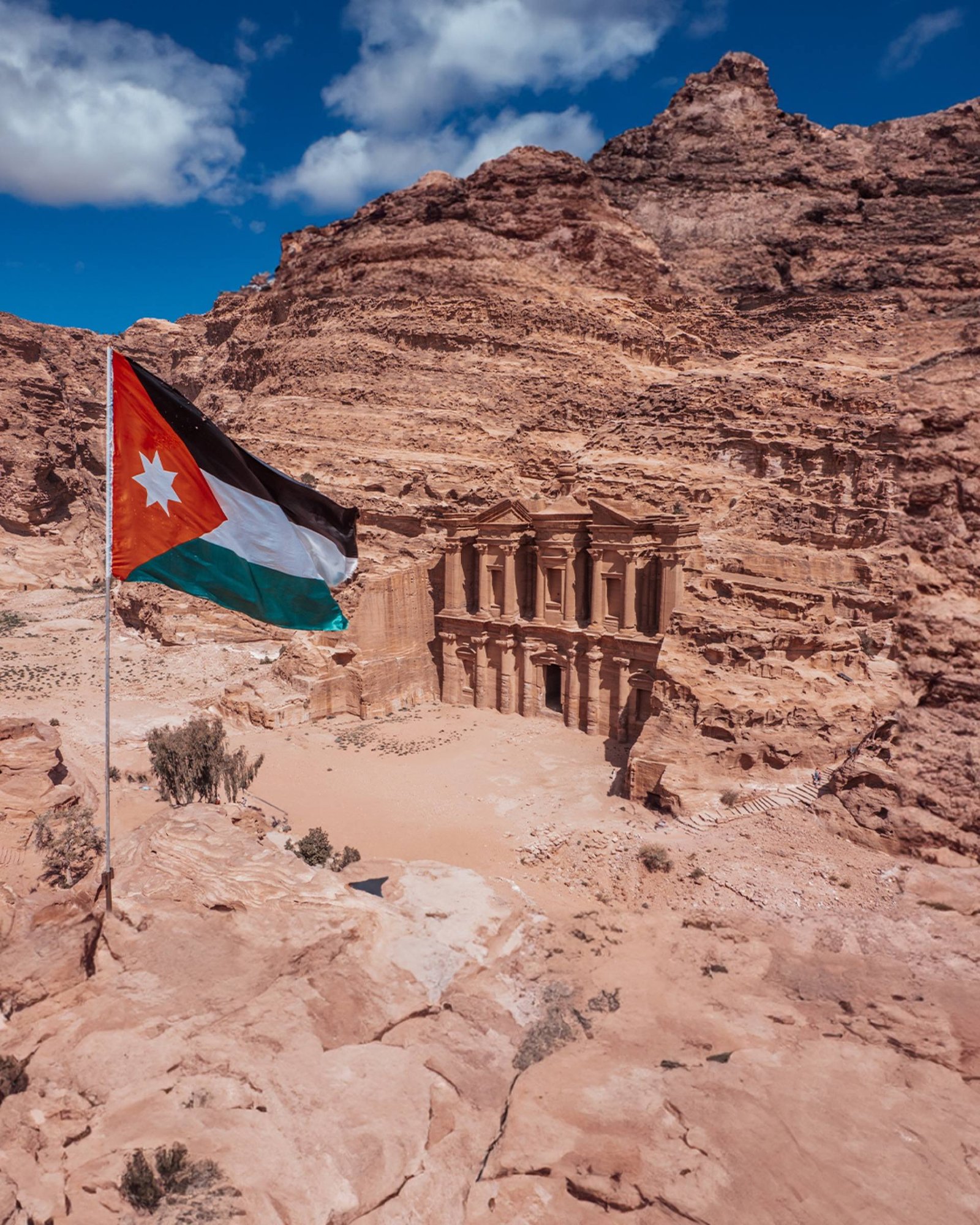 La bandiera giordana davanti al Monastero di Petra scolpito nella roccia