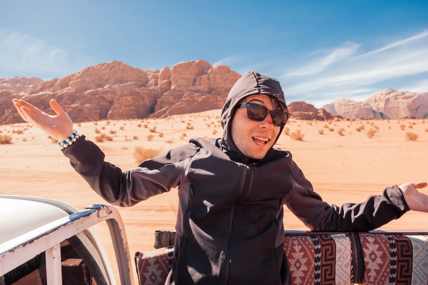 Un viaggiatore a braccia aperte nel deserto del Wadi Rum