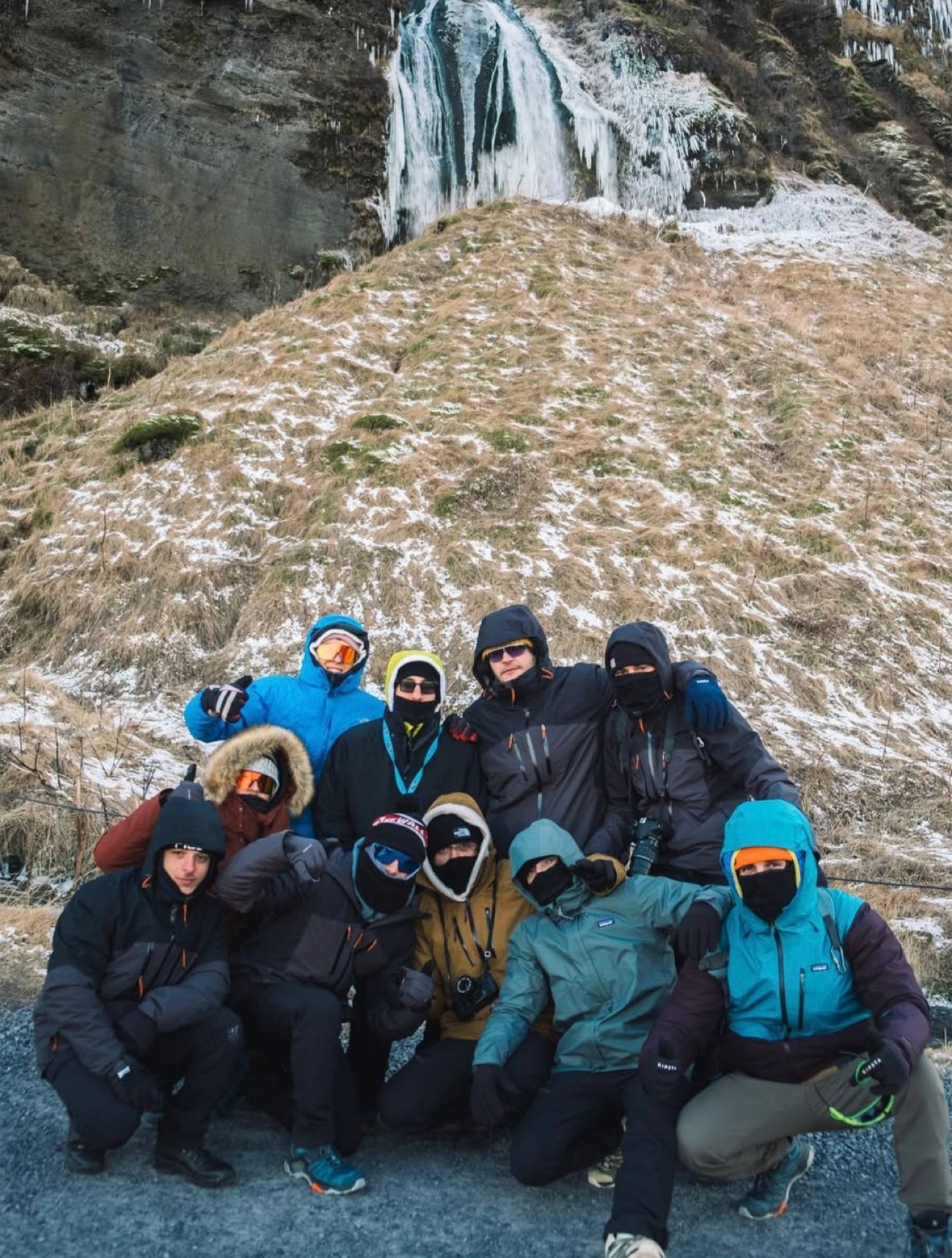 Un gruppo di fotografi sulla neve davanti a una cascata in Islanda
