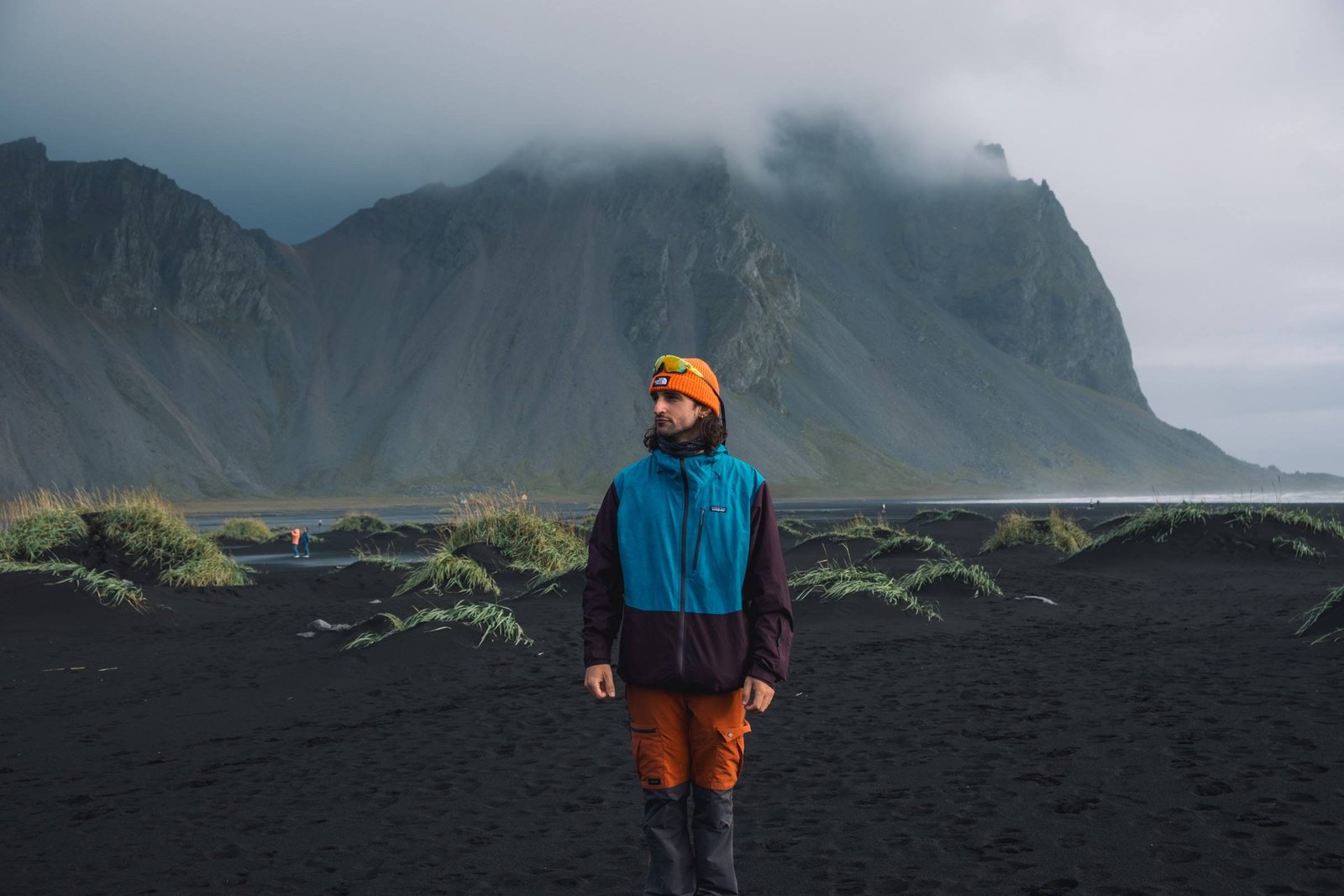 Un viaggiatore sulla sabbia nera di Stokksnes davanti al Vestrahorn