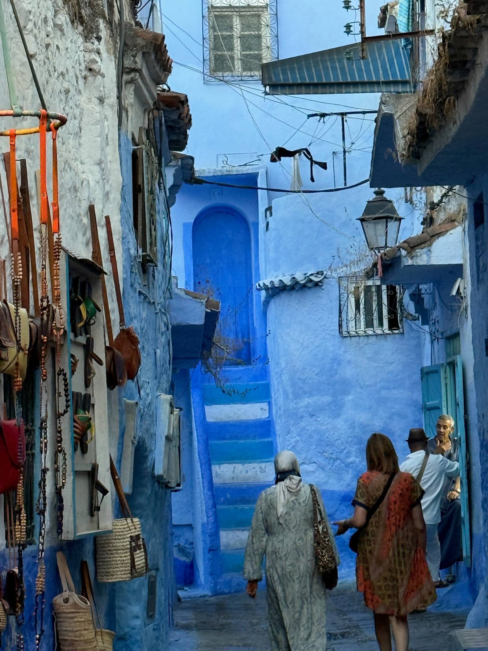 Passanti nei vicoli blu di Chefchaouen in Marocco