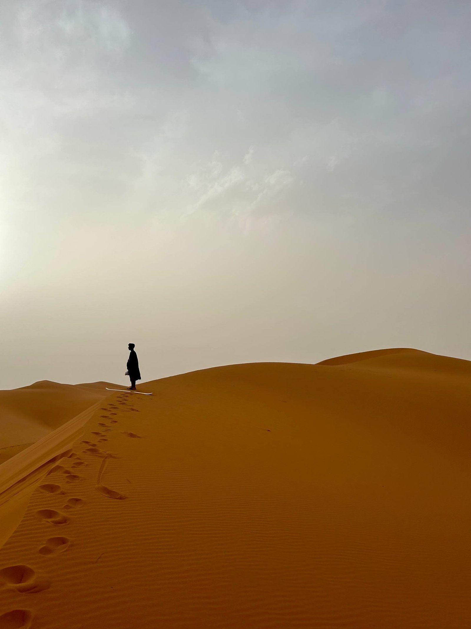 Una persona in cima a una duna del Sahara in Marocco