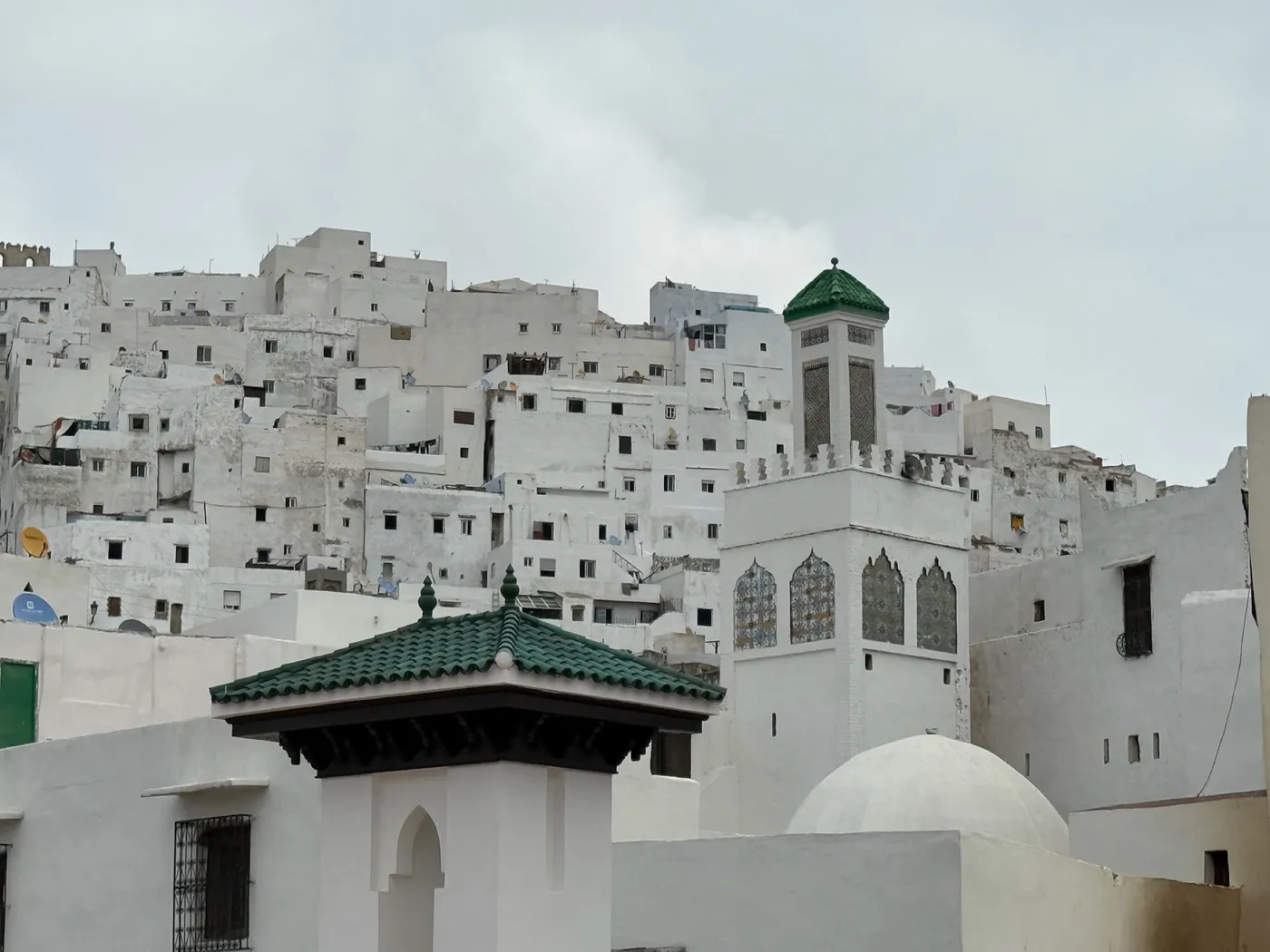 Una via di Tétouan con le case bianche e una cupola verde